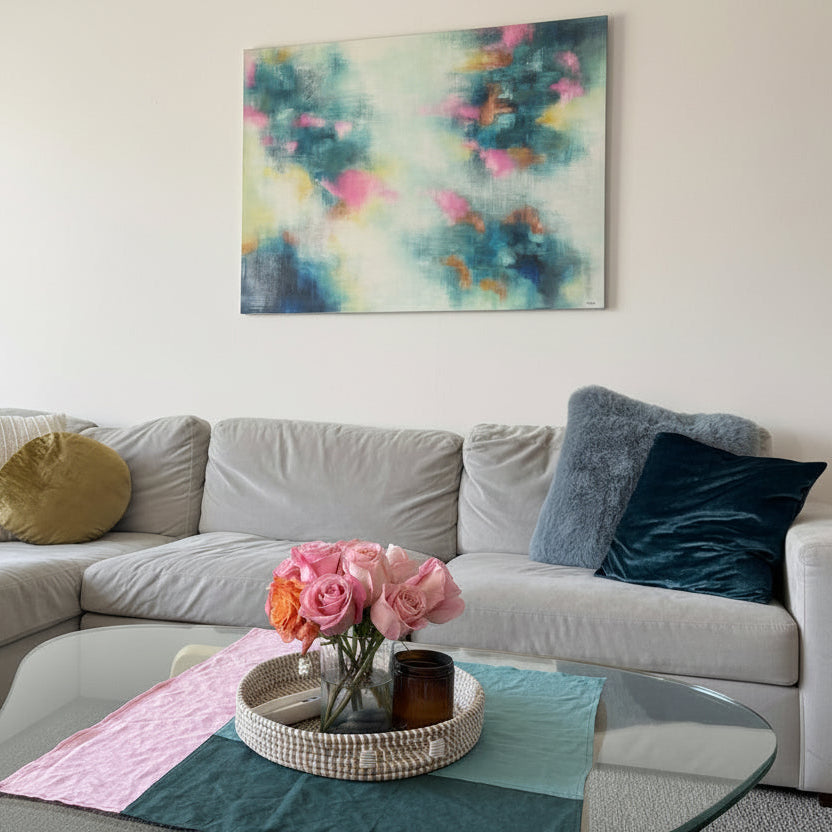 Living room with a sofa, decorative pillows, and a colorful abstract painting on the wall.