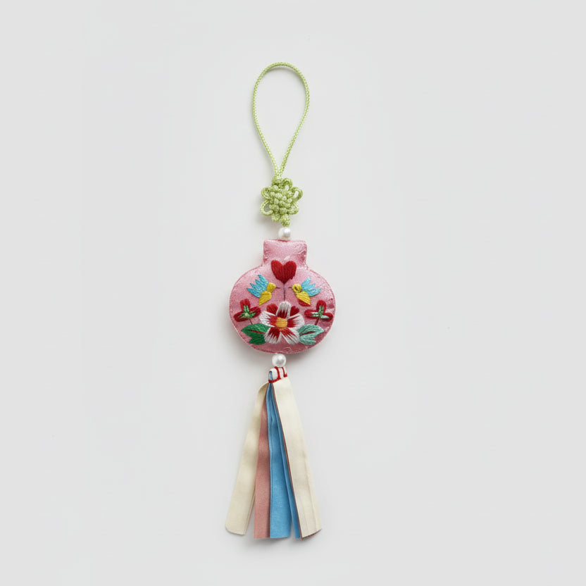 Decorative heart-shaped charm with colorful details on a textured gray background