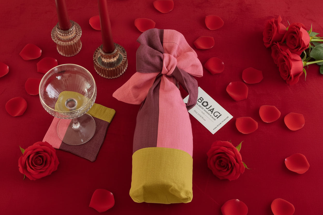 Colorful folded fabric with a bow, glass, and coasters on a dark surface
